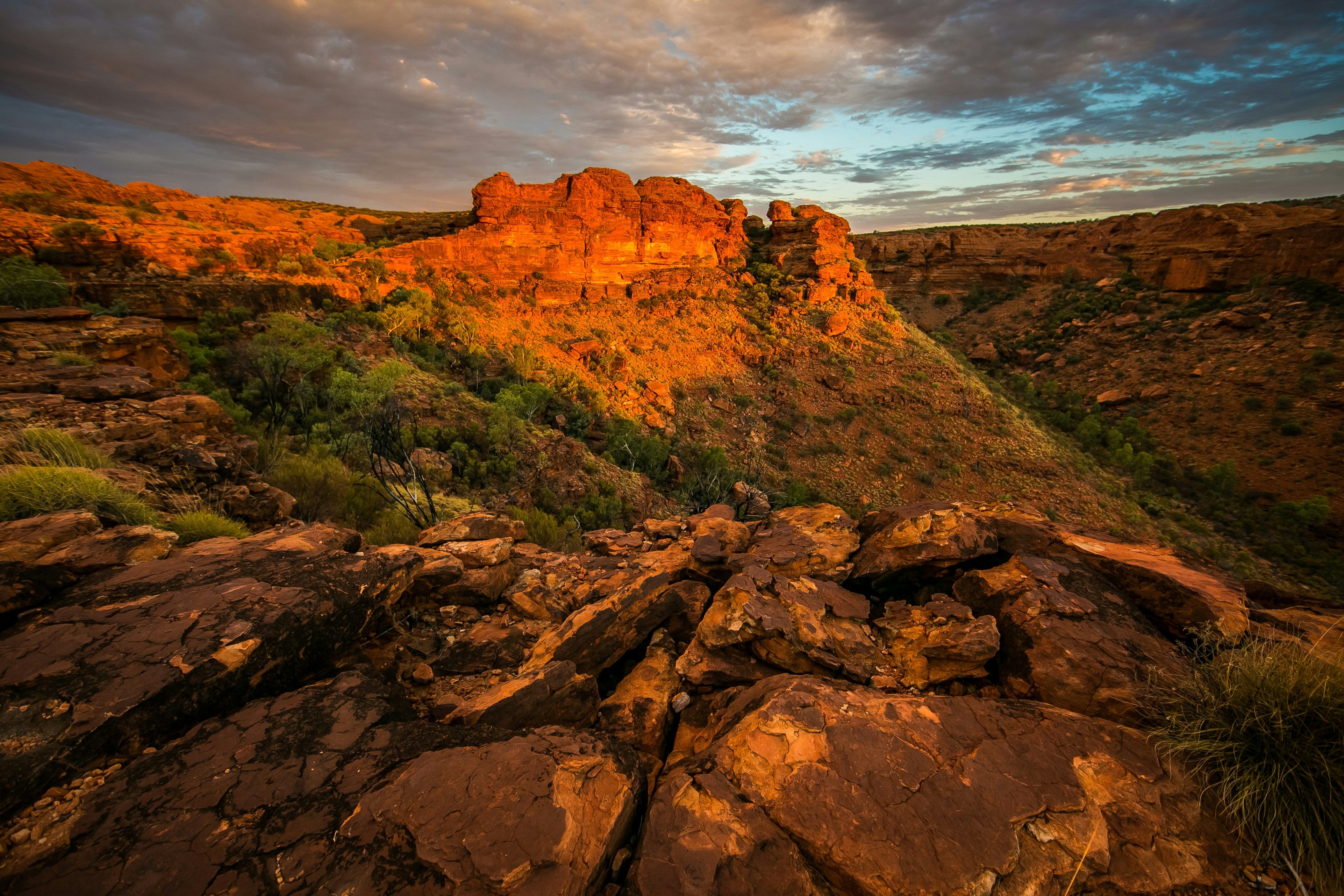 Voyage en Australie - Falaises escarpées et formations rocheuses orangées de Kings Canyon sous la lumière dorée du couchant Falaises escarpées et formations rocheuses orangées de Kings Canyon sous la lumière dorée du couchant