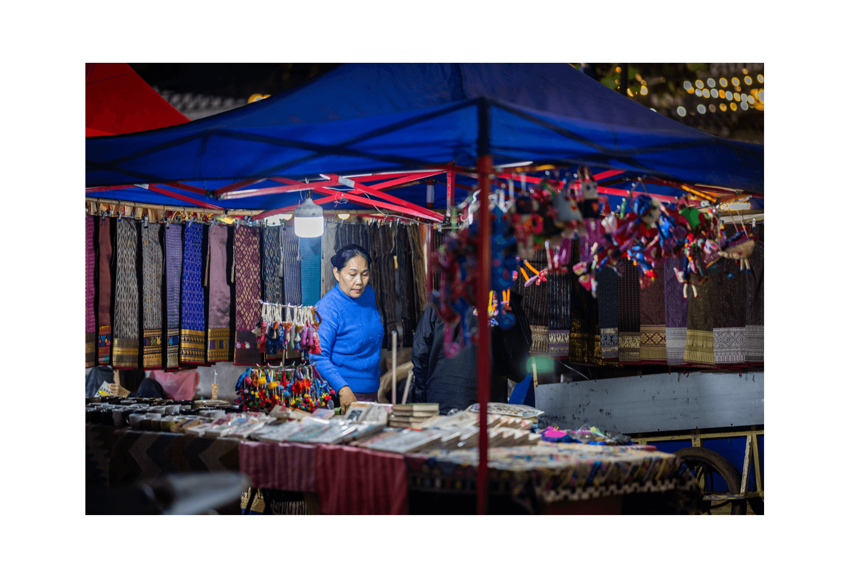 Voyage au Laos - Vendeuse d'artisanat devant son stand au Night Market de Luang Prabang